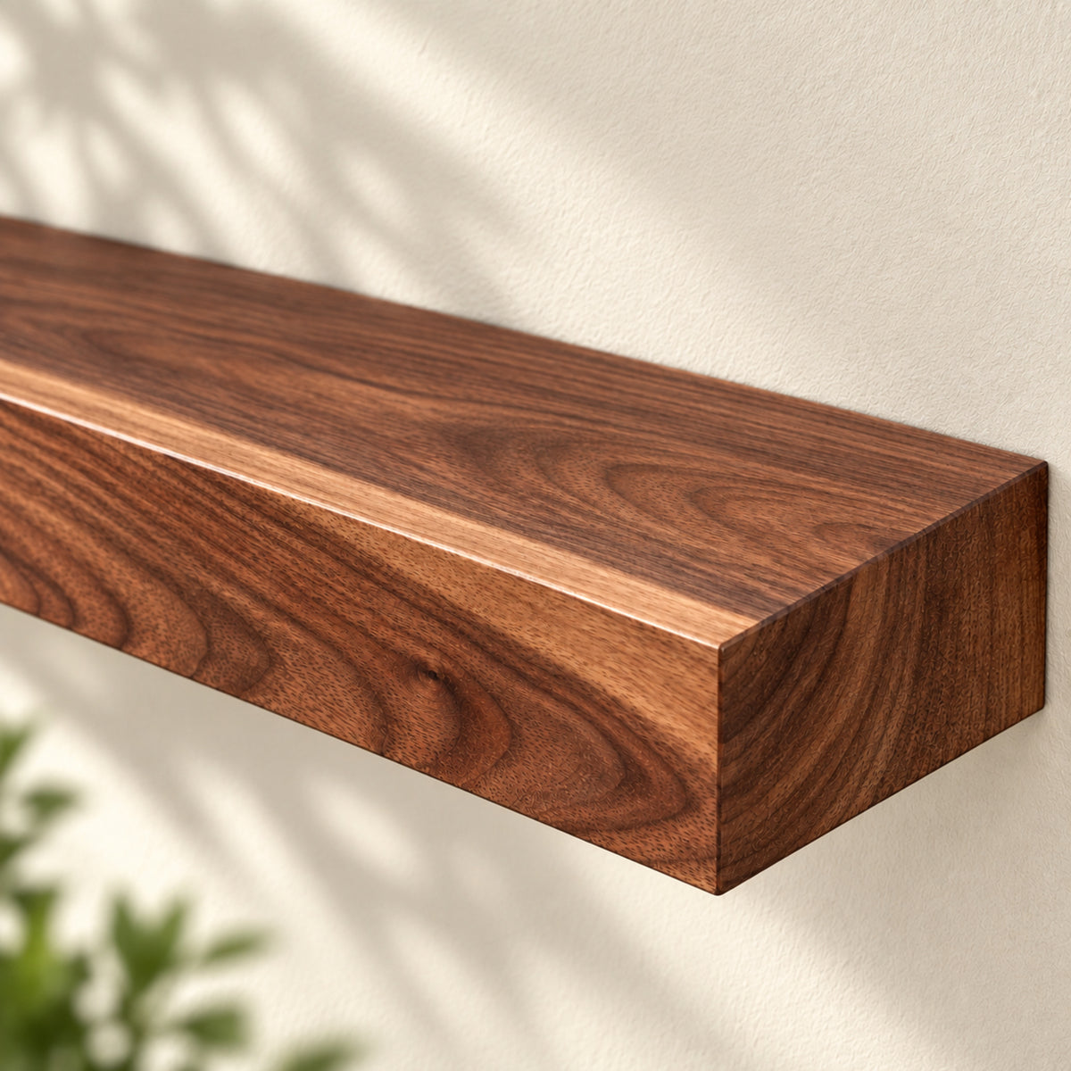A floating wooden shelf with a rich brown walnut grain finish, mounted on a textured off-white wall with soft shadow overlays.