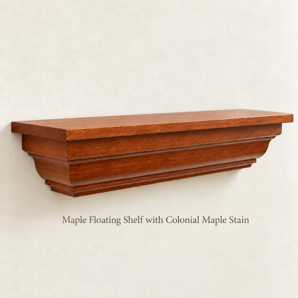 A floating shelf with a warm reddish-brown colonial maple stain, mounted on a textured off-white wall. Text below reads 'Maple Floating Shelf with Colonial Maple Stain'.