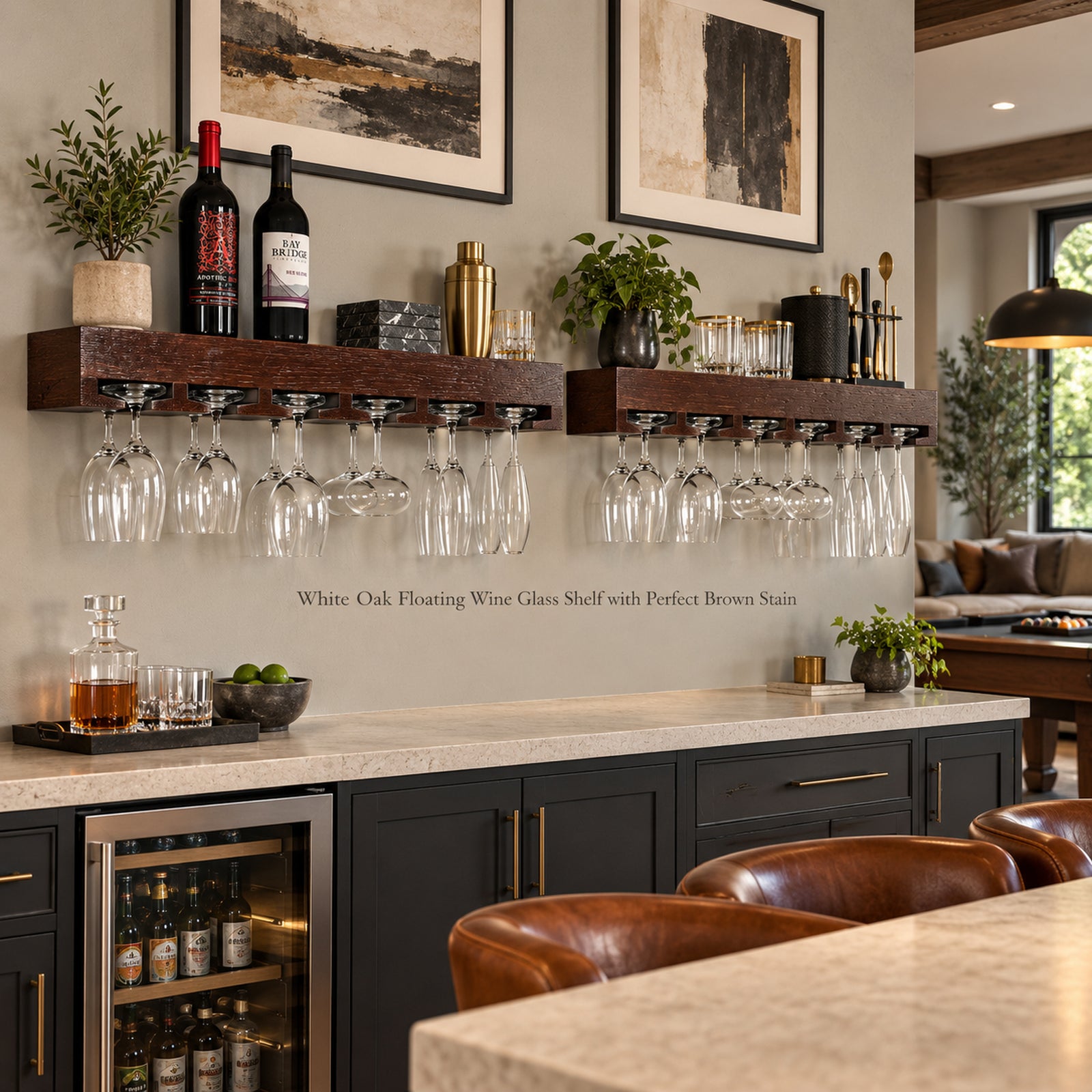 Two dark brown floating wine glass shelves mounted on a beige wall above a bar counter, holding wine glasses, stemware and bar accessories, with framed wall art and a modern home interior in the background.
